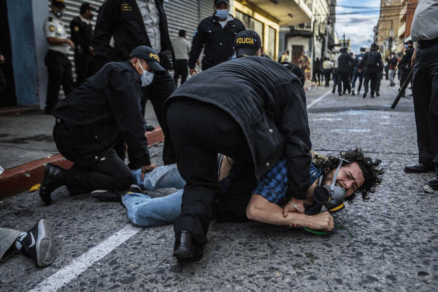Varios policías retienen a un hombre agarrándolo de pies y manos para proceder a su detención durante la protesta del 21 de noviembre del 2020. | Foto: Oliver de Ros